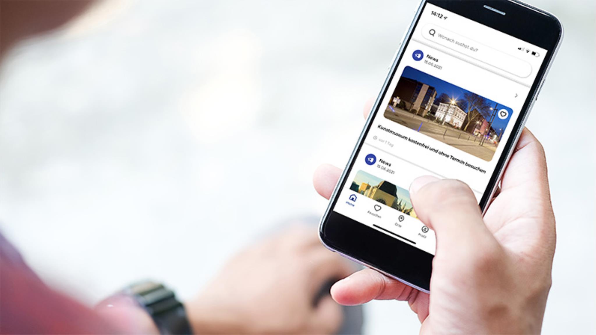 Foto: Hand, die ein Smartphone hält, auf der die City-App Gelsenkirchen zu sehen ist.