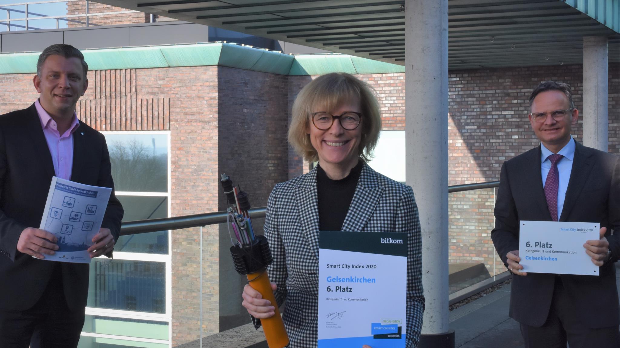 Oberbürgermeisterin Karin Welge freut sich mit Maik Luhmann (links, Beauftragter für Digitalisierung der Stadt Gelsenkirchen) und Thomas Dettenberg (rechts, Geschäftsführer der GELSEN-NET Kommunikationsgesellschaft mbH) über die Auszeichnung.