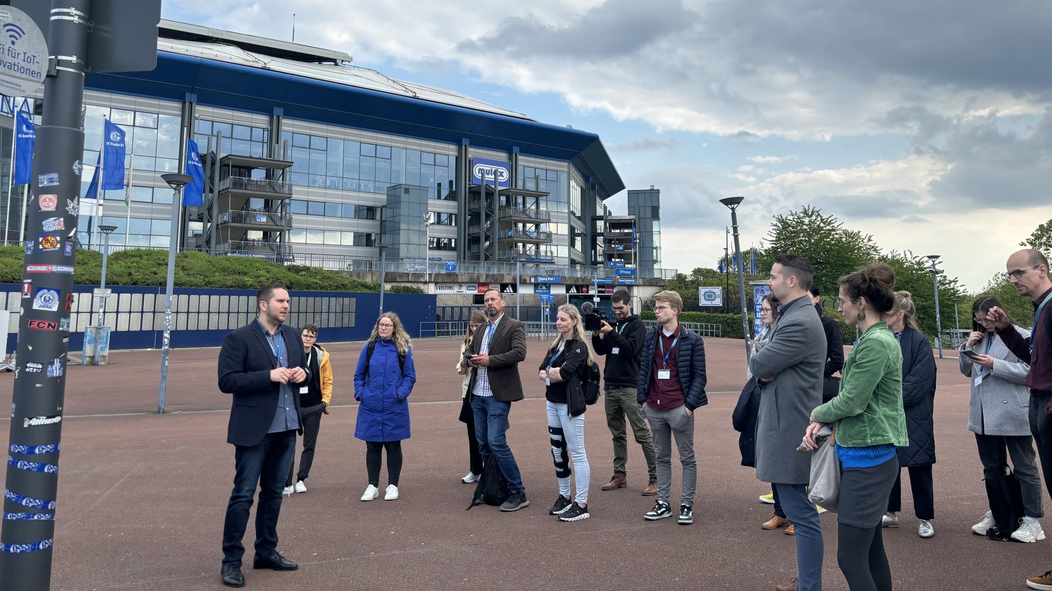 Foto: Städtischer Vertreter und Gruppe Menschen vor der Veltins-Arena versammelt vor einem Smart Pole