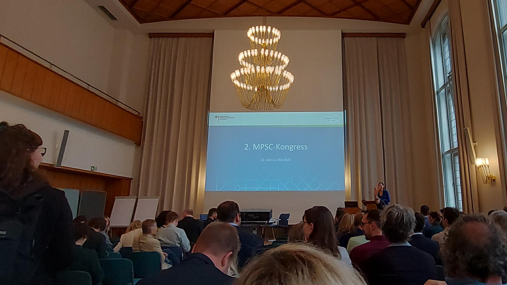 Foto: Veranstaltungsraum im Saalhaus Hamburg mit Publikum und großer Leinwand