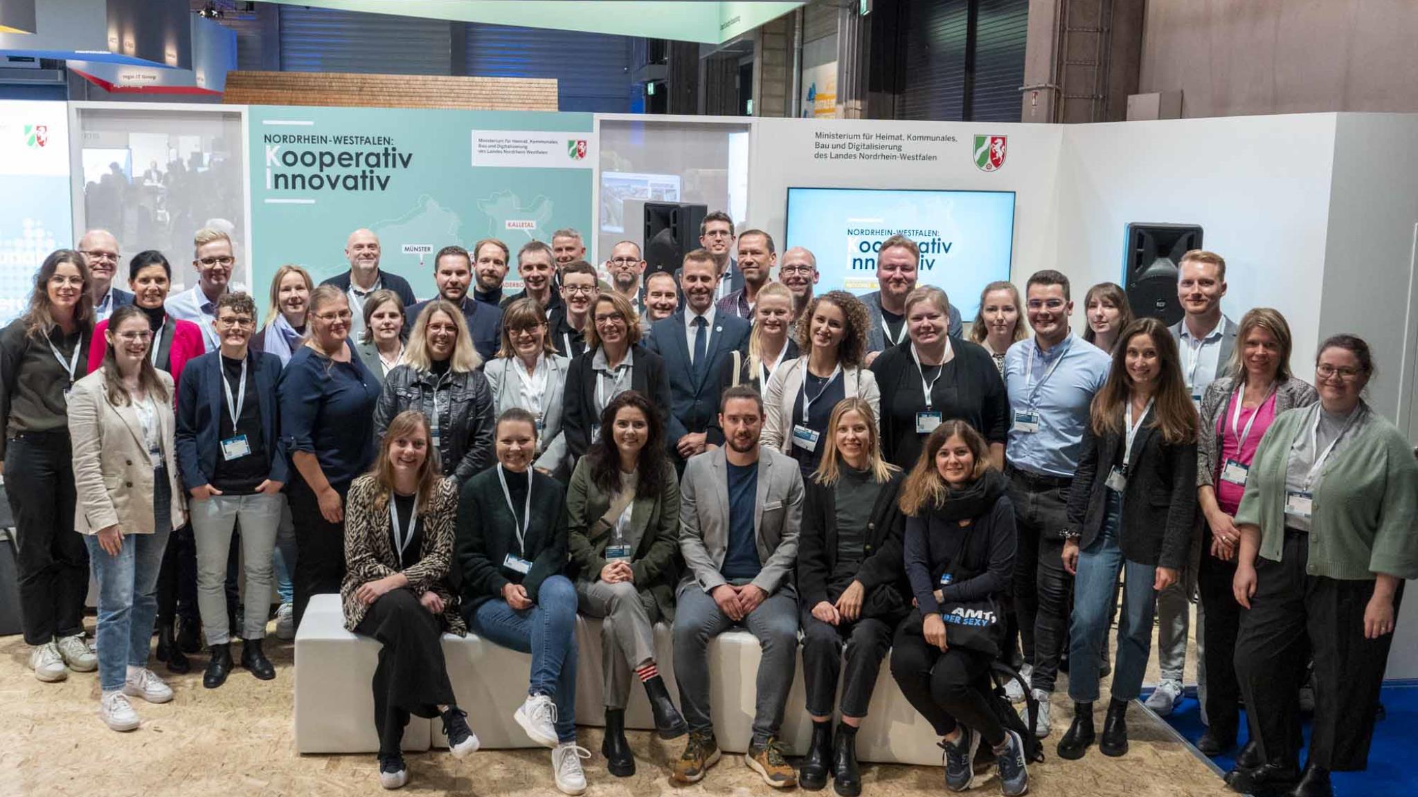 Foto: Gemeinschaftsfoto der kommunalen Vertreter auf dem Messestand des Ministeriums für Heimat, Kommunales, Bau und Digitalisierung auf der Smart Country Convention