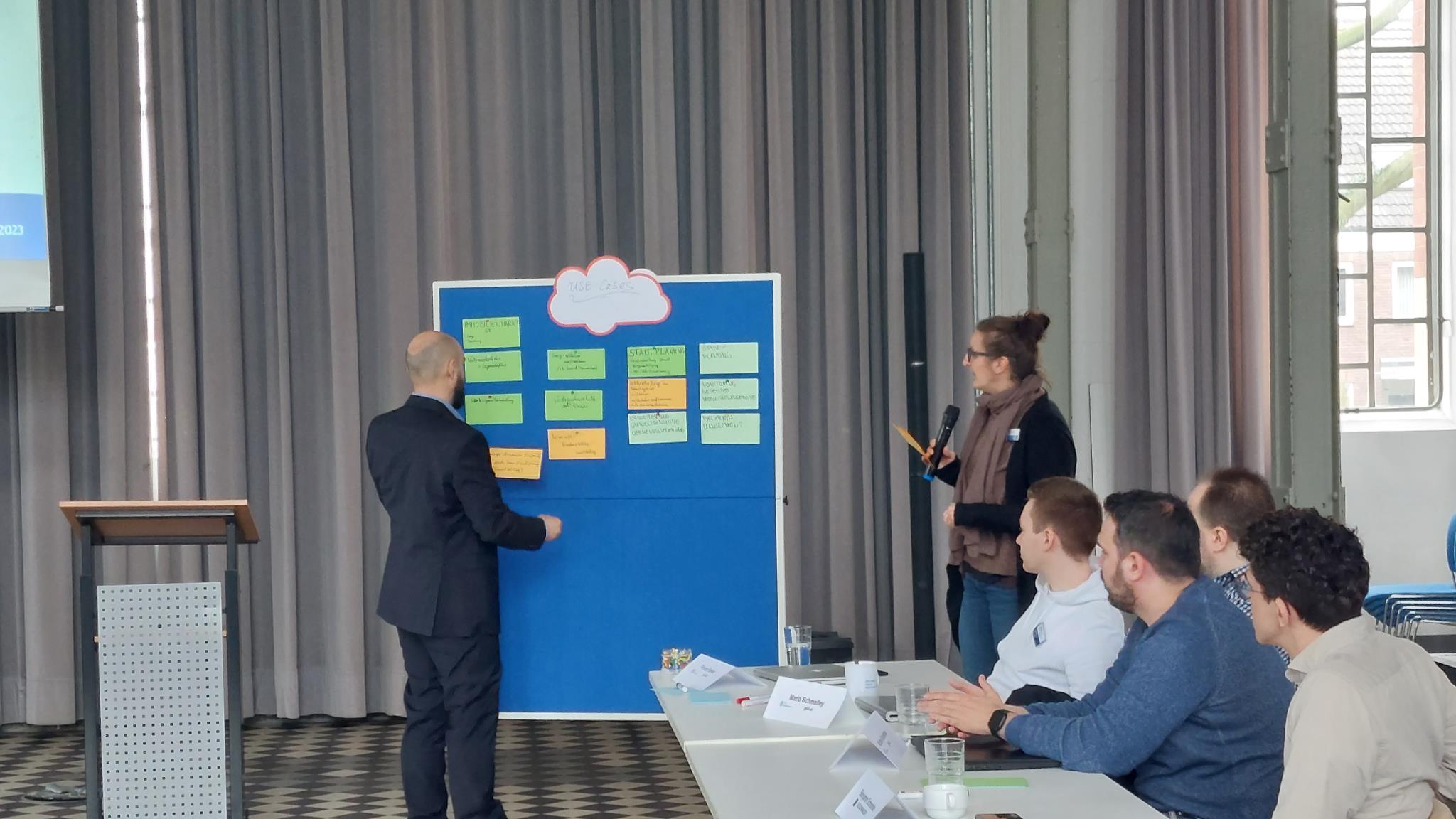 Mann steht an Stellwand im stadt.bau.raum und klebt Post-it an.